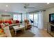Cozy living room featuring a ceiling fan, sofas, and sliding glass doors at 805 N Bay Blvd, Anna Maria, FL 34216
