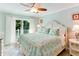 Inviting primary bedroom with a comfortable bed, ceiling fan, and access to a private balcony at 805 N Bay Blvd, Anna Maria, FL 34216
