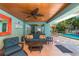 Covered outdoor living area with stylish seating offers a relaxing space, located next to the refreshing pool at 805 N Bay Blvd, Anna Maria, FL 34216