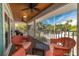 Relaxing screened patio boasts ceiling fans and comfortable seating with views of the surrounding tropical landscape at 805 N Bay Blvd, Anna Maria, FL 34216