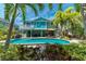 Beautiful backyard featuring a private pool, covered patio, and lush tropical landscaping at 805 N Bay Blvd, Anna Maria, FL 34216