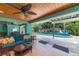 A beautiful pool area with covered seating, a lounge area, and lush tropical landscaping create a private oasis at 805 N Bay Blvd, Anna Maria, FL 34216