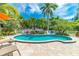 Beautiful kidney-shaped pool surrounded by a stone patio and tropical landscaping at 805 N Bay Blvd, Anna Maria, FL 34216