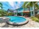 Backyard pool featuring an orange umbrella and lounge chairs for outdoor relaxation at 805 N Bay Blvd, Anna Maria, FL 34216