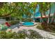 Backyard pool with lush tropical foliage, and seating around the patio area at 805 N Bay Blvd, Anna Maria, FL 34216