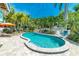 Gorgeous kidney-shaped pool surrounded by lush tropical greenery and stone pavers at 805 N Bay Blvd, Anna Maria, FL 34216