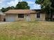 Charming single story home featuring a well manicured lawn, attached garage, and classic curb appeal at 831 Bacon Ave, Sarasota, FL 34232