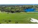 Scenic golf course with a meandering path, sand traps, and views of a tranquil pond at 9641 Castle Point Dr # 1211, Sarasota, FL 34238