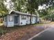 Side exterior view of the home with a blue door, white siding and a small, grassy area at 1002 E Ida St, Tampa, FL 33603