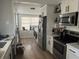 Modern kitchen featuring white cabinets, stainless steel appliances and light wood flooring at 1002 E Ida St, Tampa, FL 33603