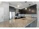 Modern kitchen with stainless steel appliances, granite counters, and stylish black cabinetry at 1064 N Tamiami Trl # 1604, Sarasota, FL 34236