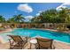 Serene swimming pool with lounge chairs, lush landscaping, and clear blue water for relaxation at 1064 N Tamiami Trl # 1604, Sarasota, FL 34236