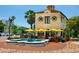 Quaint restaurant exterior with outdoor seating, a water fountain, and vibrant yellow umbrellas creating a charming dining atmosphere at 1064 N Tamiami Trl # 1604, Sarasota, FL 34236