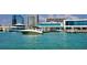 Picturesque waterfront scene featuring a sleek motorboat cruising past a restaurant and marina, highlighting a vibrant coastal lifestyle at 1064 N Tamiami Trl # 1604, Sarasota, FL 34236