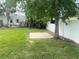 Lush backyard with grassy expanse, mature trees and vegetation, concrete pad at 109 Colonia W Ln, Nokomis, FL 34275