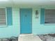 Inviting home entrance with a bright turquoise door and matching shutters on either side at 109 Colonia W Ln, Nokomis, FL 34275