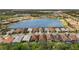 Community aerial view features homes surrounding a scenic lake with water features and beautiful landscaping at 11499 Renaissance Blvd, Venice, FL 34293