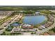 Panoramic aerial view showcasing a vibrant community with lake, pool, tennis courts, and lush greenery at 11499 Renaissance Blvd, Venice, FL 34293