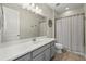 Clean bathroom with a single vanity, large mirror, and a shower with a curtain at 11499 Renaissance Blvd, Venice, FL 34293