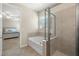 Bright bathroom showcasing a tub and separate glass shower, adjacent to a bedroom at 11499 Renaissance Blvd, Venice, FL 34293
