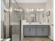 Modern bathroom featuring dual sinks with gray cabinets and a glass-enclosed shower at 11499 Renaissance Blvd, Venice, FL 34293