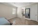 Bedroom with wood-look tile floor, a window, a door and doorway leading to the bathroom at 11499 Renaissance Blvd, Venice, FL 34293