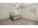 Neutral bedroom with natural lighting, wood-look tile floor, ceiling fan and a comfortable bed at 11499 Renaissance Blvd, Venice, FL 34293