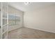 Bright, empty bedroom with tile flooring and a large window allowing natural light at 11499 Renaissance Blvd, Venice, FL 34293