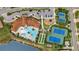 Aerial view of community amenities: a luxurious pool, tennis courts, playground, and ample parking at 11499 Renaissance Blvd, Venice, FL 34293