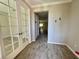 Bright entryway features wood-look tile flooring, with glass paneled french doors leading to an office at 11499 Renaissance Blvd, Venice, FL 34293