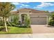 Charming single-story home with lush landscaping, brick driveway, and a beautiful terracotta tile roof at 11499 Renaissance Blvd, Venice, FL 34293