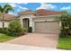 Attractive home showcasing a well-manicured lawn and a paver driveway, complemented by a tan exterior at 11499 Renaissance Blvd, Venice, FL 34293
