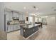 Open kitchen with gray cabinets, granite countertops, stainless steel appliances, and open to dining and living areas at 11499 Renaissance Blvd, Venice, FL 34293