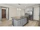 Kitchen island with gray cabinets, granite countertop, and stainless steel appliances at 11499 Renaissance Blvd, Venice, FL 34293