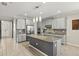 Modern kitchen featuring gray cabinets, a spacious island, tile backsplash, and stainless steel appliances at 11499 Renaissance Blvd, Venice, FL 34293