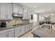Kitchen with gray cabinets, granite countertops, stainless steel appliances and open to the living area at 11499 Renaissance Blvd, Venice, FL 34293