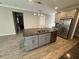 Kitchen featuring a granite island with stainless steel appliances and custom cabinets at 11499 Renaissance Blvd, Venice, FL 34293