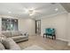 Relaxing living room featuring a comfortable sectional, tile flooring, and sliding glass doors to the patio at 11499 Renaissance Blvd, Venice, FL 34293