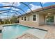Screened in backyard pool with brick pool deck, ceiling fan and view of backyard landscaping at 11499 Renaissance Blvd, Venice, FL 34293