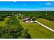 Expansive aerial view of a house with a long driveway, set within a lush green landscape, presenting a serene estate at 1208 Oak Hammock Rd, Sarasota, FL 34240