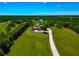 Scenic aerial view of a home with a long driveway, surrounded by lush greenery, exemplifying privacy and tranquility at 1208 Oak Hammock Rd, Sarasota, FL 34240