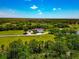 Stunning aerial view of a property with a lush green landscape, featuring a house and pond, highlighting its idyllic setting at 1208 Oak Hammock Rd, Sarasota, FL 34240