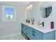 Bright bathroom with double sinks, quartz countertop, blue cabinets, and mosaic-framed mirrors at 1208 Oak Hammock Rd, Sarasota, FL 34240