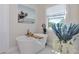Bright bathroom features a freestanding tub, white tile and light from the window at 1208 Oak Hammock Rd, Sarasota, FL 34240