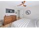 Well-lit bedroom with wood-look floors, light walls, ceiling fan and decorative mirror at 1208 Oak Hammock Rd, Sarasota, FL 34240