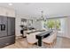 Dining area with a modern black table, seating for six, and a view of the landscaped yard at 1208 Oak Hammock Rd, Sarasota, FL 34240