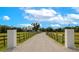 Grand driveway entrance, marked by decorative pillars and fencing, leading to a secluded and inviting property at 1208 Oak Hammock Rd, Sarasota, FL 34240