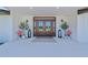 Inviting entryway featuring double doors, sconces, potted plants, and an entrance mat at 1208 Oak Hammock Rd, Sarasota, FL 34240