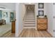 Entryway with stairs and a modern cabinet, showcasing light wood floors at 1208 Oak Hammock Rd, Sarasota, FL 34240