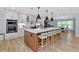 Bright kitchen with an expansive island, wooden base, white countertop and cabinets, and pendant lighting at 1208 Oak Hammock Rd, Sarasota, FL 34240